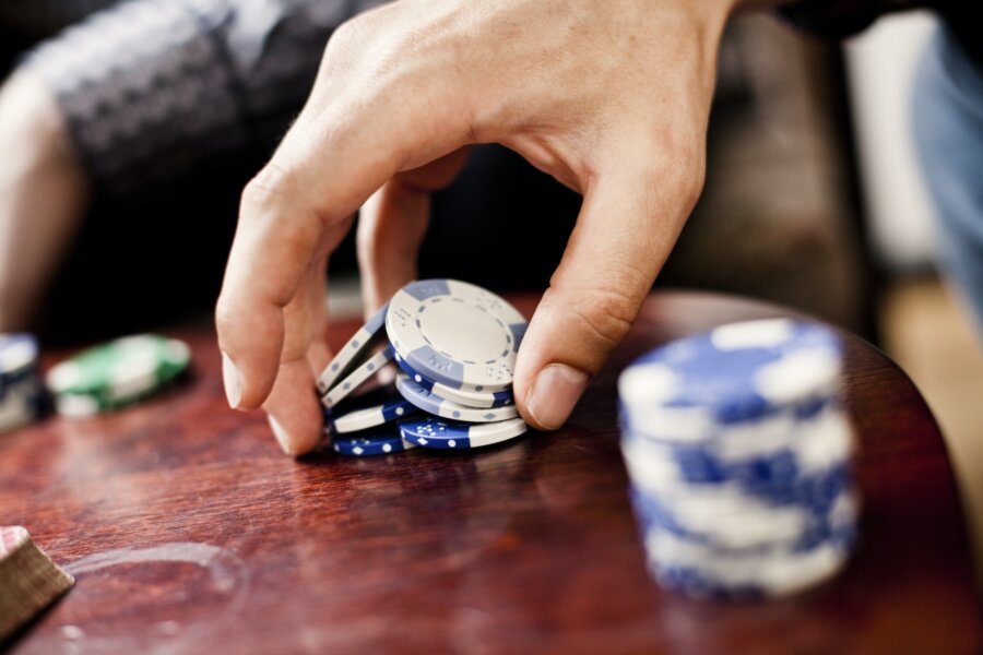 Image of hand holding poker chips